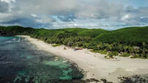 Playa bajo colinas de hierba, isla Yasawa