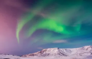 Northern Lights over Snowy Hills near Reykjavík