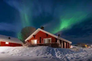 Casita roja bajo la aurora boreal, Finlandia